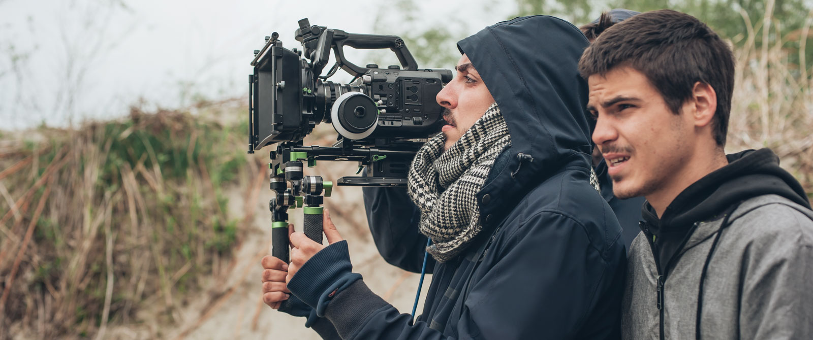 Camarógrafo y director de perfil, filmando en exterior.